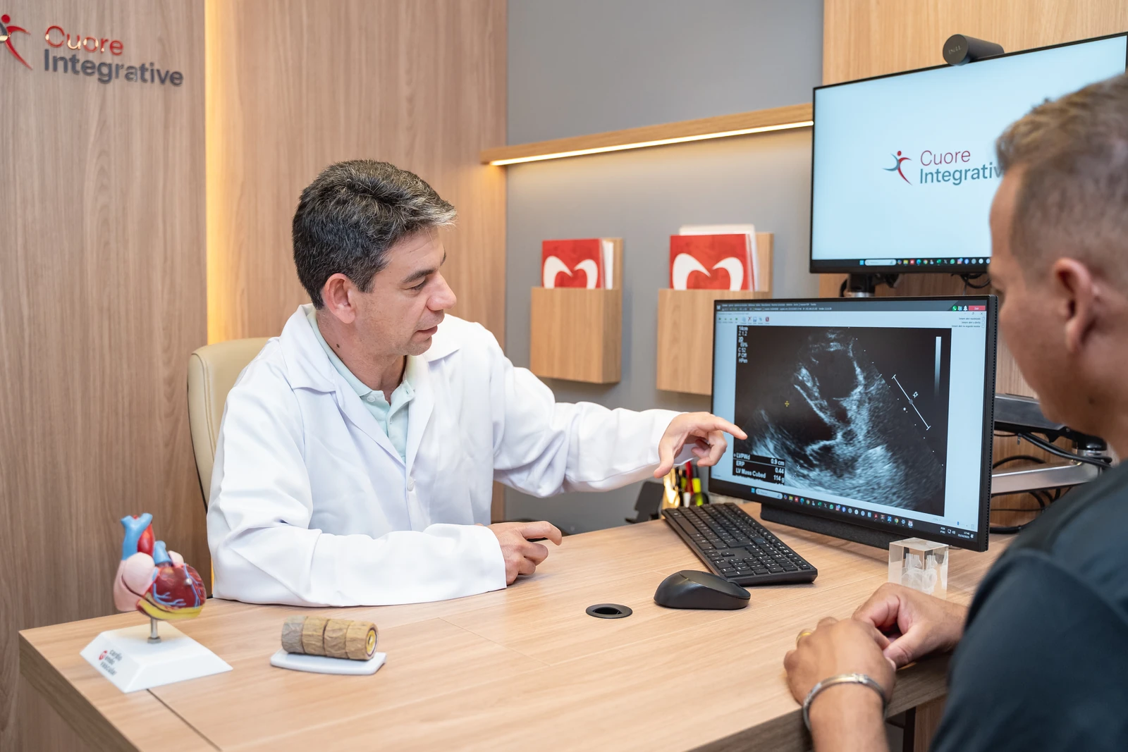 Dr. Alexandre Fernandes analisando exame de ecocardiograma com paciente na Cuore Integrative