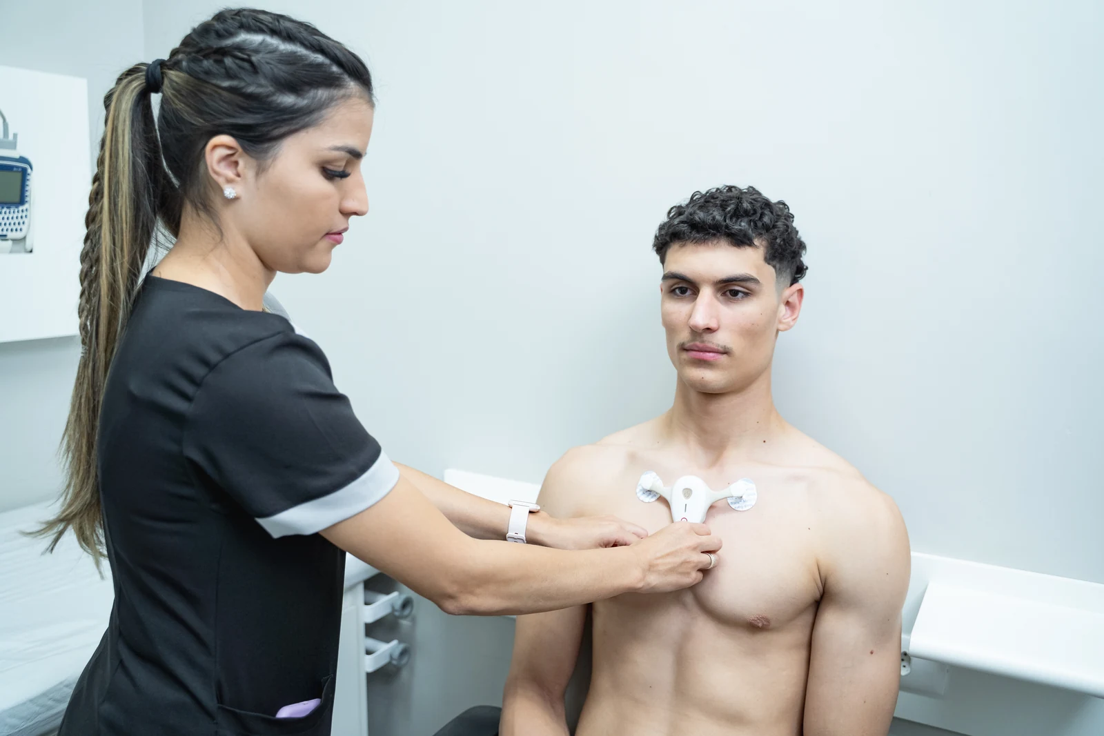 Enfermeira posicionando o Holter sem fio no tórax do paciente